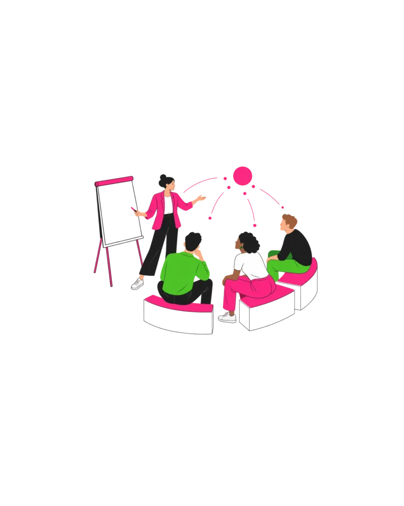 Trainerin steht am Flipchart und arbeitet mit einer Gruppe, die im Halbkreis sitzt