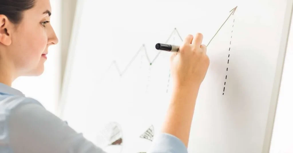 Frau zeichnet etwas auf Flipchart